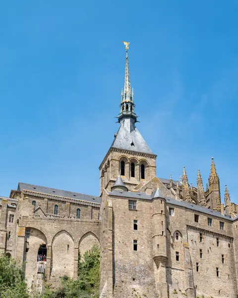 Abația de pe Mont-Saint-Michel, cu turla gotică, sub cer albastru