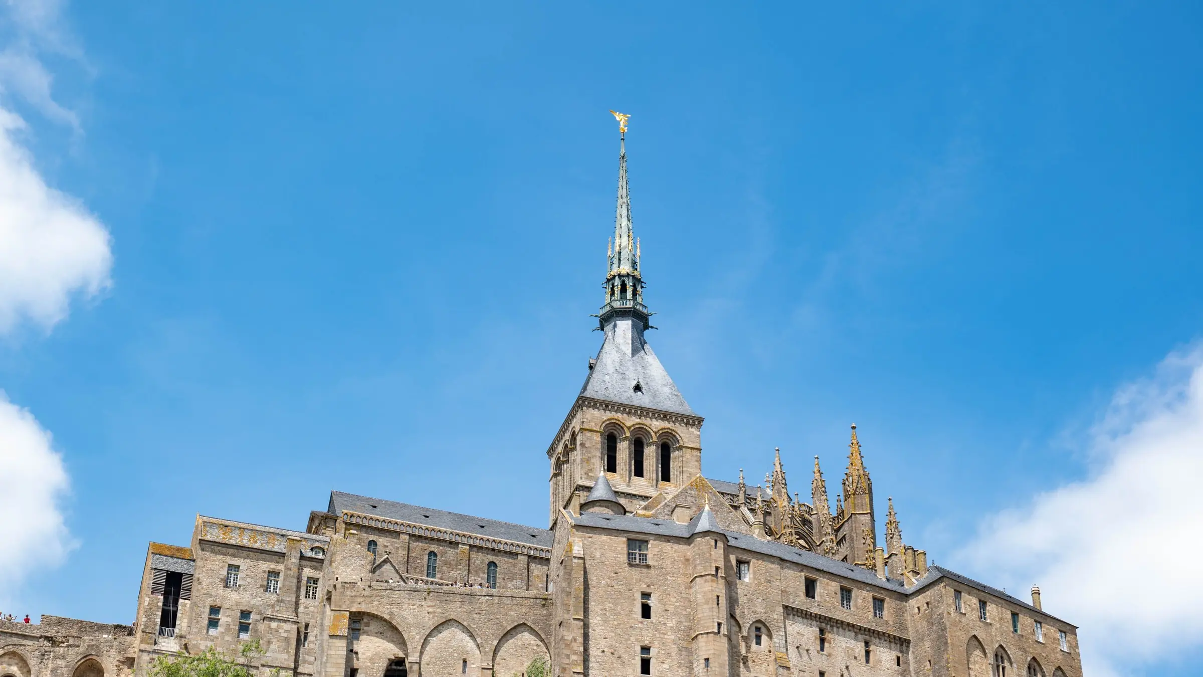 Abația de pe Mont-Saint-Michel, cu turla gotică, sub cer albastru