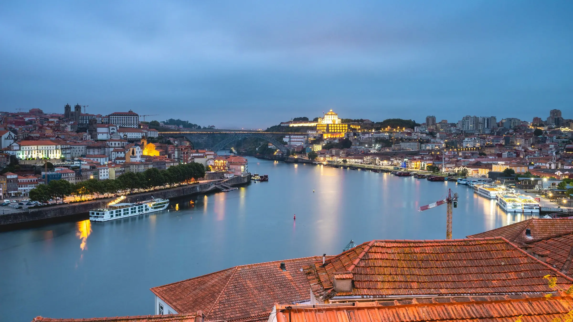 Porto la apus, cu râul Douro și acoperișurile de țiglă din prim-plan