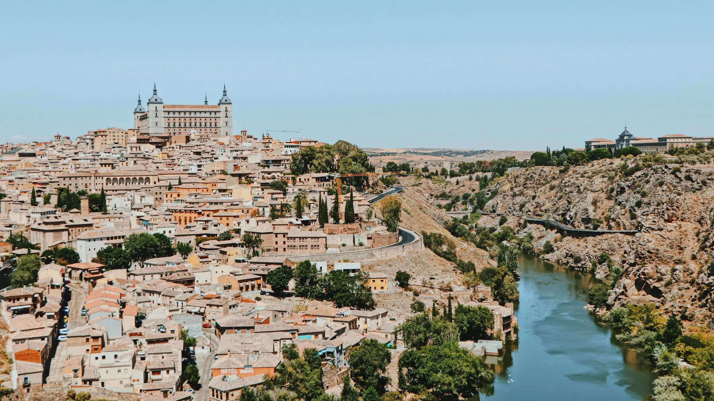 Toledo pe deal, cu Alcázarul deasupra orașului vechi și râul Tajo în defileu