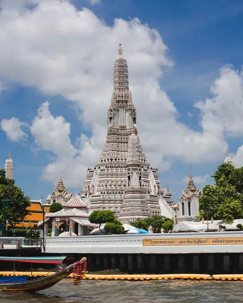 Templul Wat Arun din Bangkok și o barcă longtail pe râul Chao Phraya