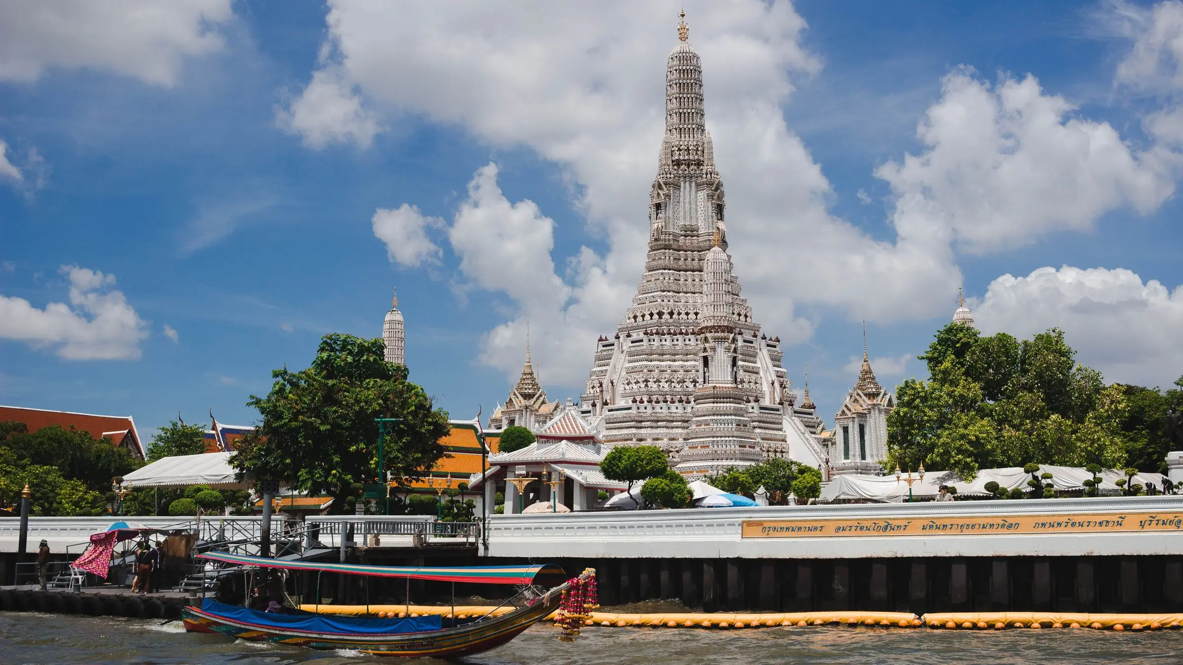Templul Wat Arun din Bangkok și o barcă longtail pe râul Chao Phraya