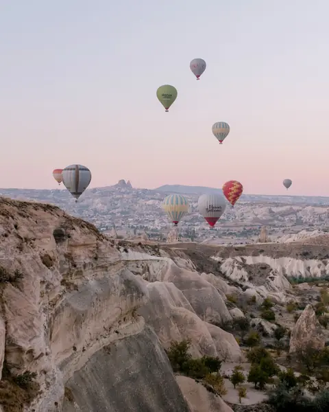 Baloane cu aer cald la răsărit deasupra văilor de tuf din Cappadocia