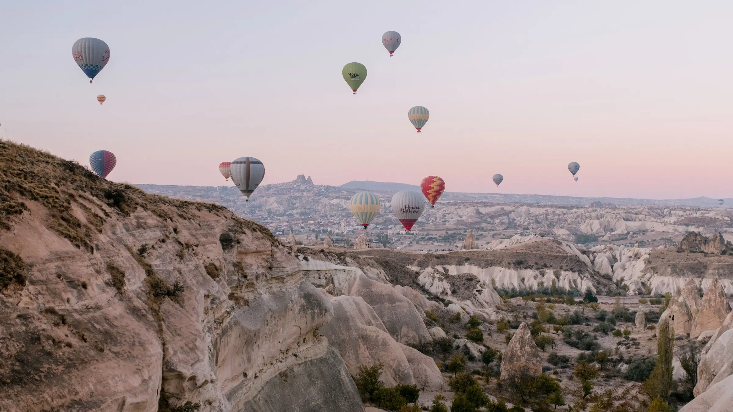 Baloane cu aer cald la răsărit deasupra văilor de tuf din Cappadocia