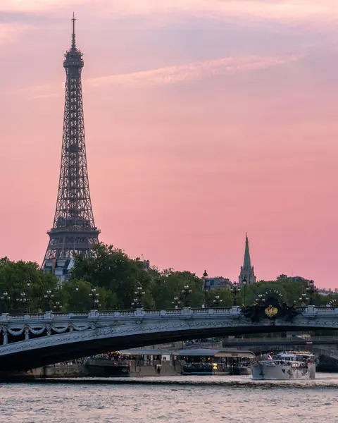 Turnul Eiffel și podul Alexandre III peste Sena, la apus, sub cer roz