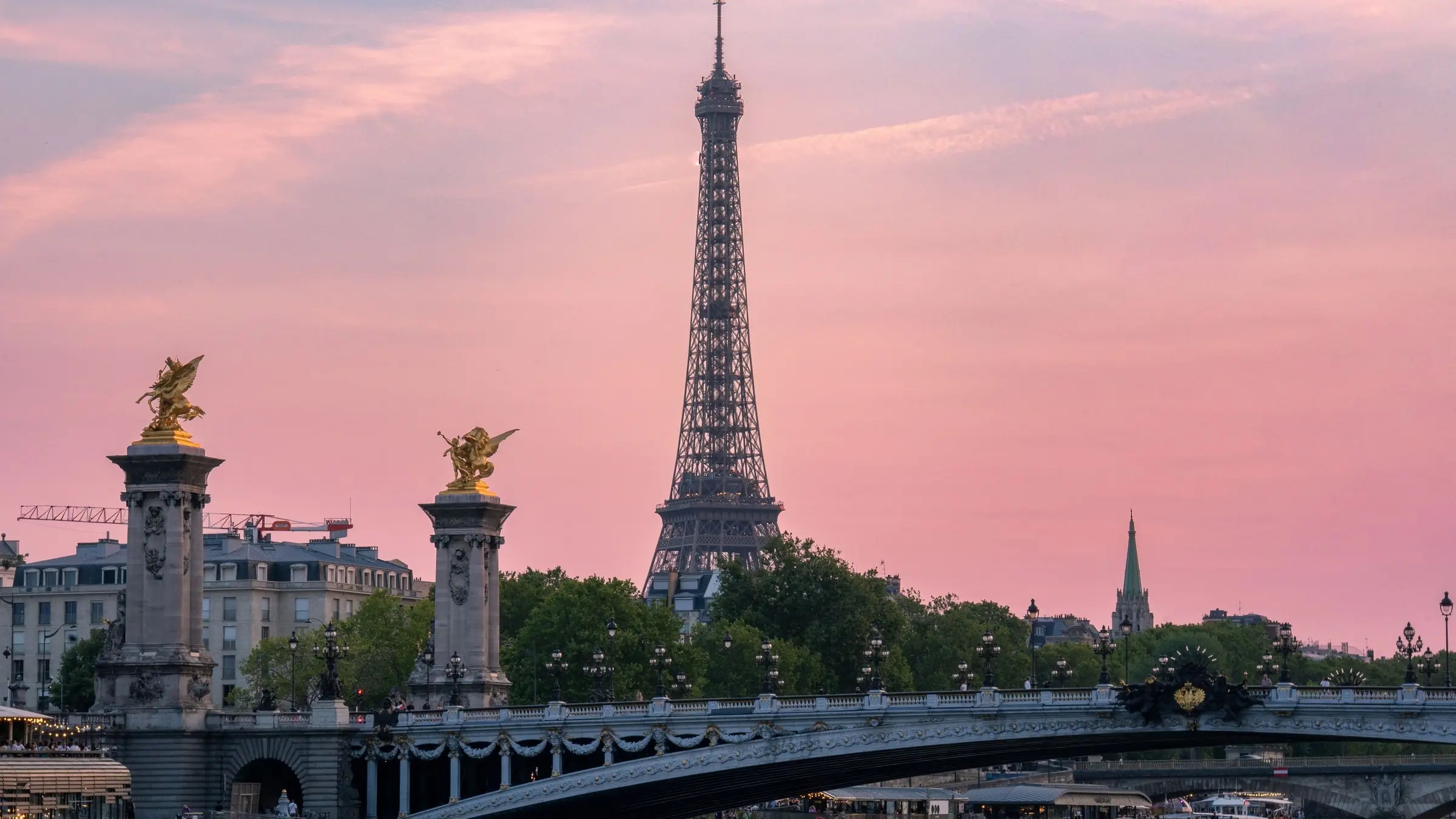 Turnul Eiffel și podul Alexandre III peste Sena, la apus, sub cer roz