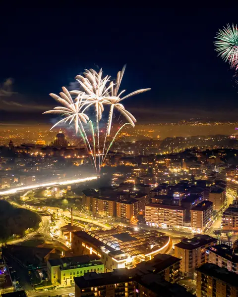 Artificii de Revelion deasupra unui oraș luminat noaptea