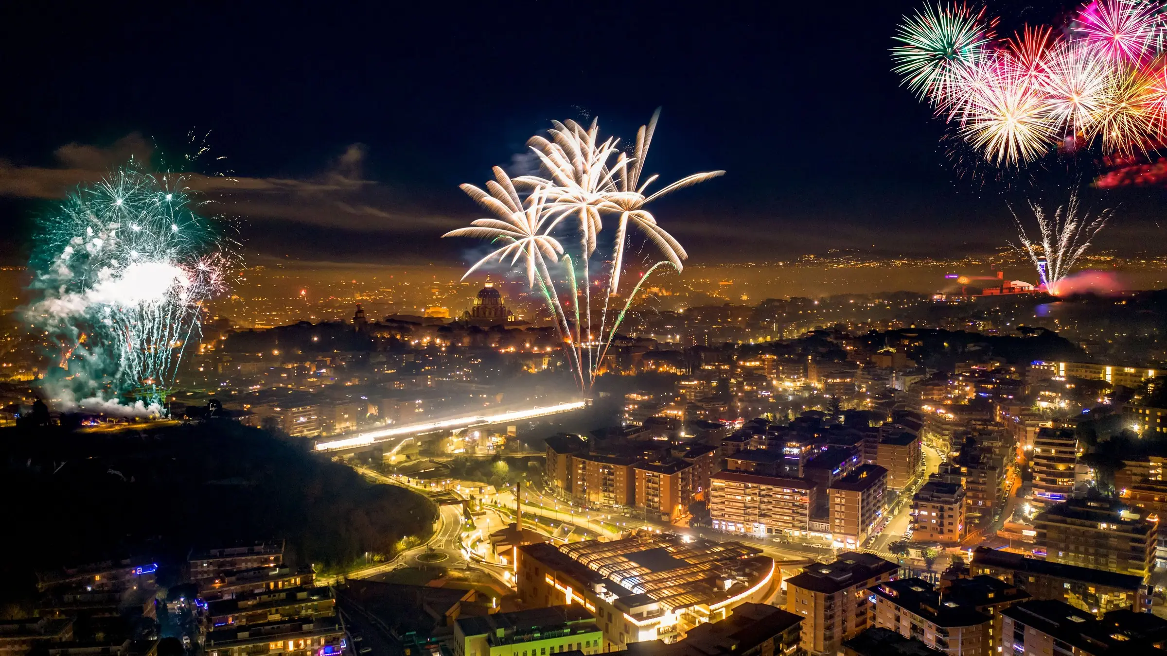 Artificii de Revelion deasupra unui oraș luminat noaptea