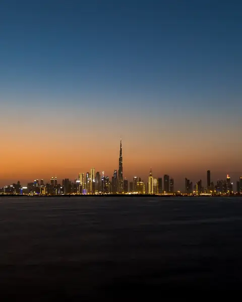 Silueta orașului Dubai cu Burj Khalifa, la amurg, văzută de pe mare