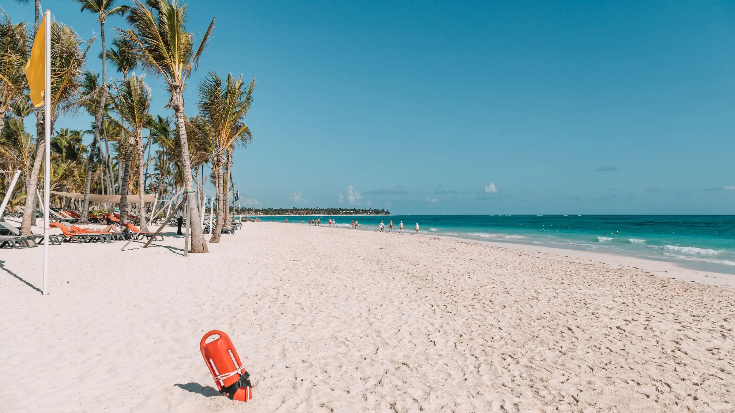 Plajă cu nisip alb și palmieri în Punta Cana, lângă apa turcoaz