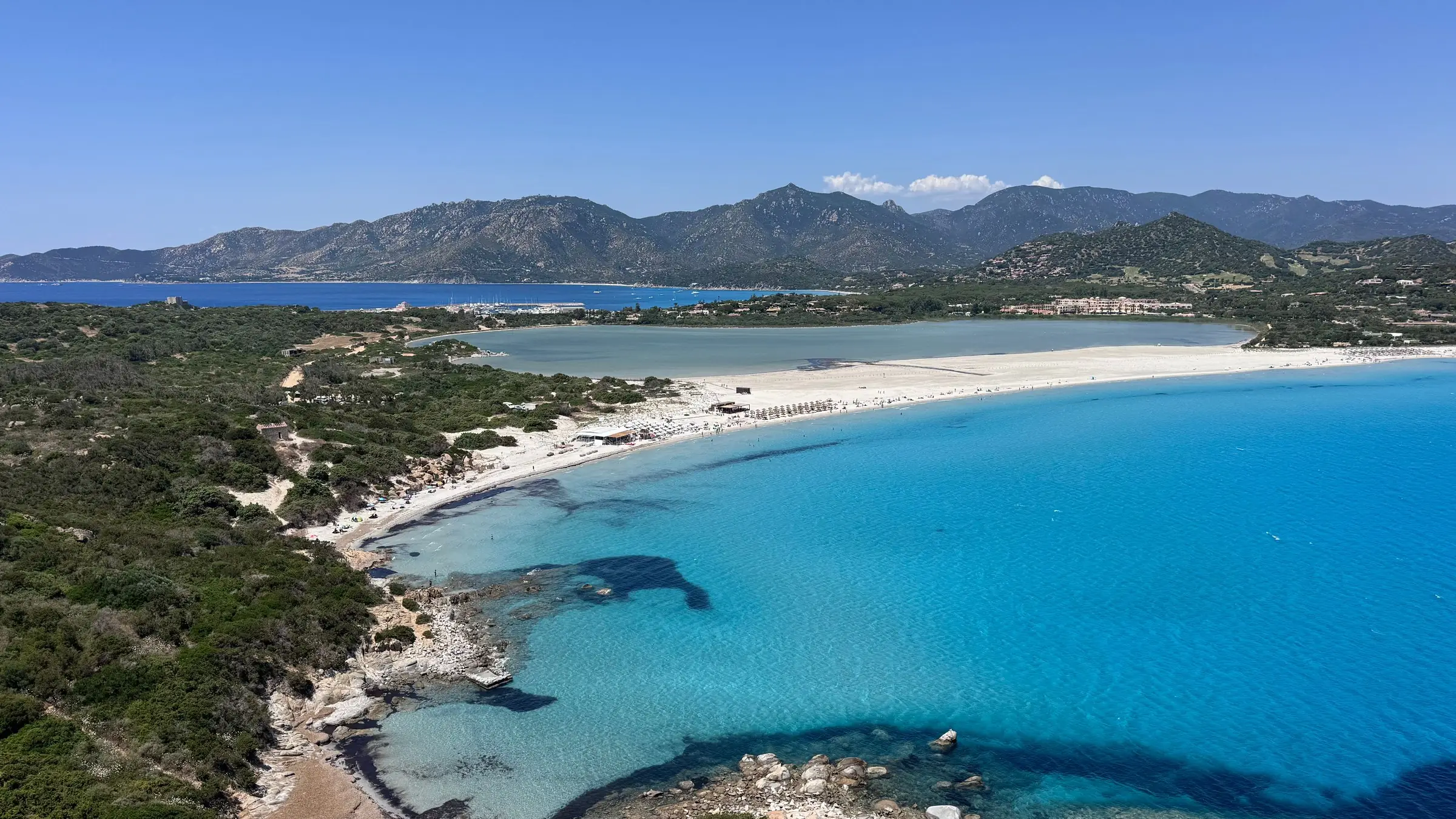 Golf cu apă turcoaz și plajă lungă de nisip alb, văzut de sus, în Sardinia